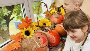 Dzieci oglądające dary jesieni w kąciku przyrodniczym