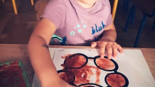 Dziecko maluje farbą palcami