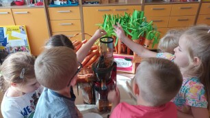 Dzieci wyciskają sok z marchewki