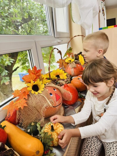 Dzieci oglądające dary jesieni w kąciku przyrodniczym