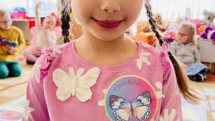 Dziewczynka z przyklejoną odznaką z okazji Dnia Motyla