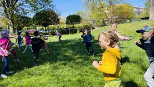 Dzieci biegają i bawią się hula hop w ogrodzie